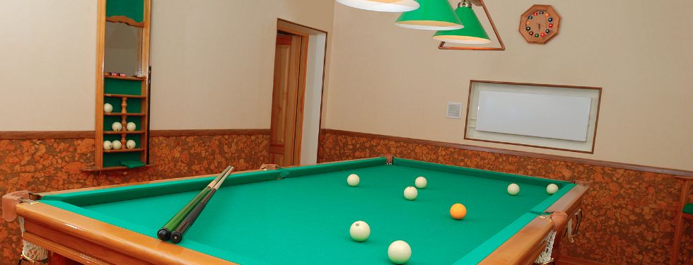 A game room with a pool rack and lighting, well-accessorized.